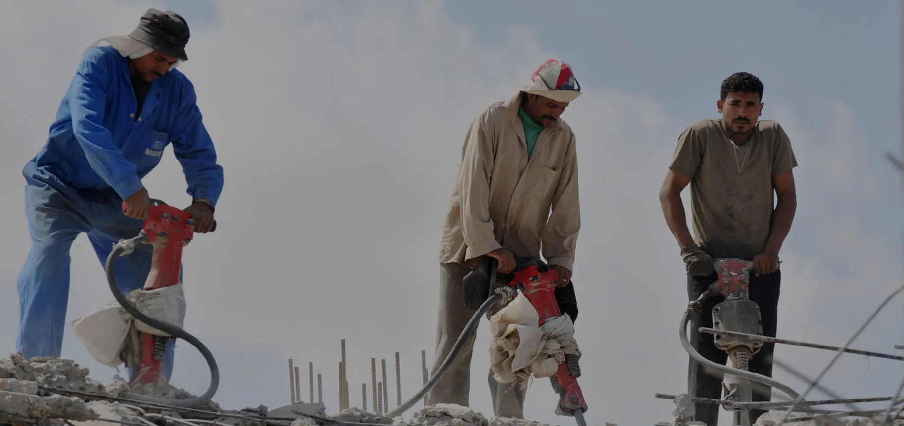 Construction workers carrying bricks at a work site